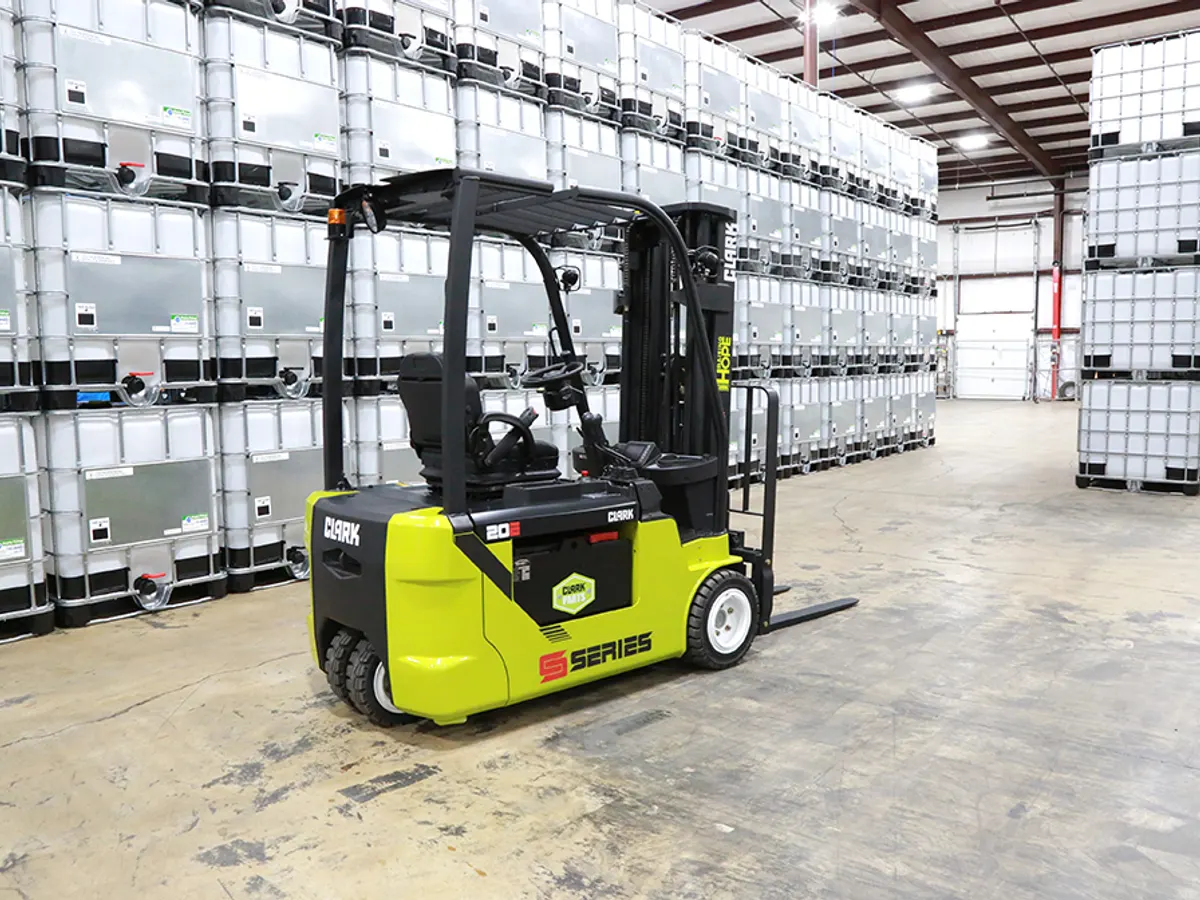 Clark electric forklift in a warehouse aisle lined with stacked tote containers
